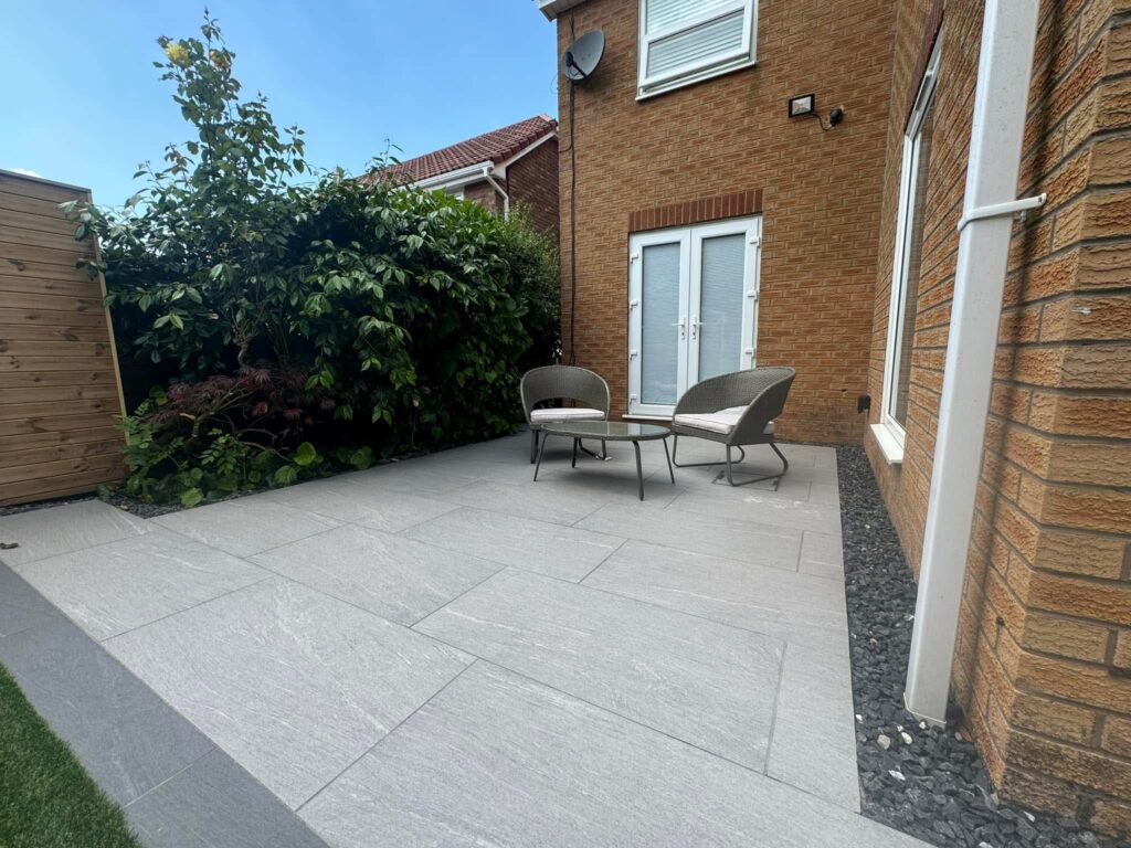 A modern backyard patio with light grey stone paving