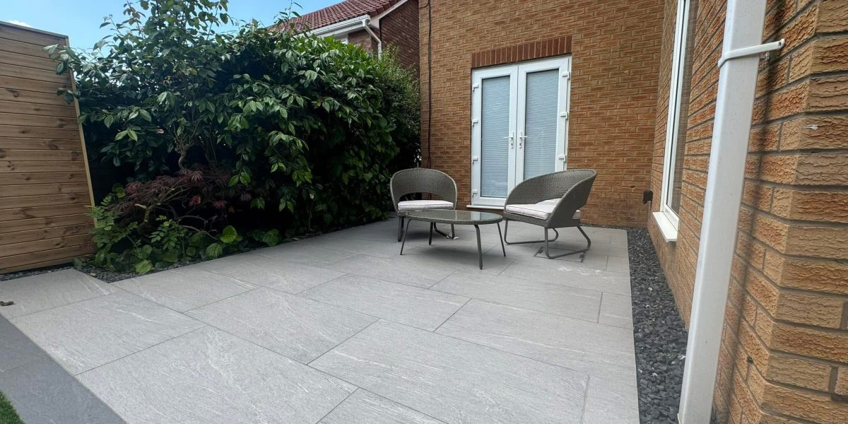 A modern backyard patio with light grey stone paving